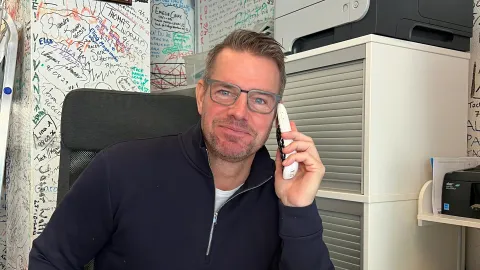 Arne på kontoret framför namnväggen